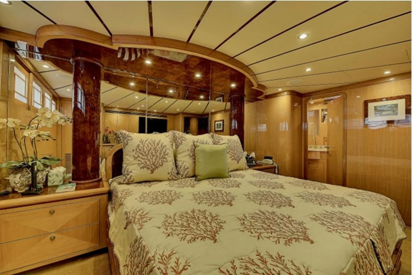 a bed with a white sheet and pillows in a room with wood walls aboard ANACAPA Yacht for Sale