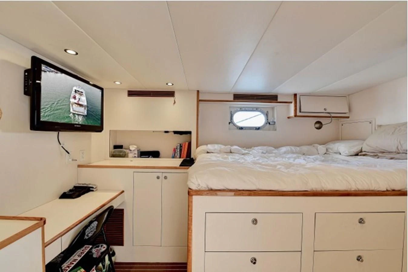 a bedroom with a television and a bed aboard ANACAPA Yacht for Sale