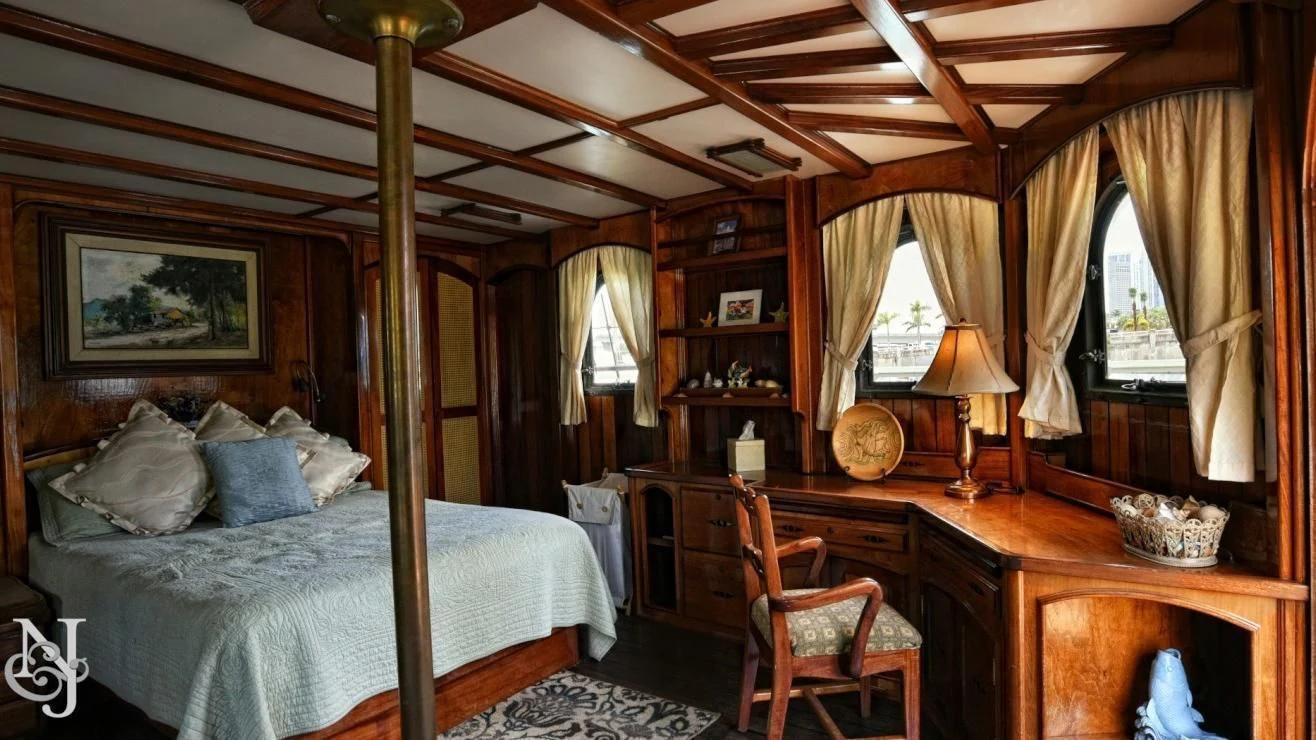 a bedroom with a bed and desk aboard PEACEMAKER Yacht for Sale