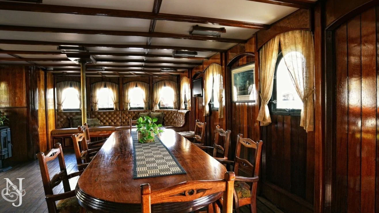 a room with a table and chairs aboard PEACEMAKER Yacht for Sale