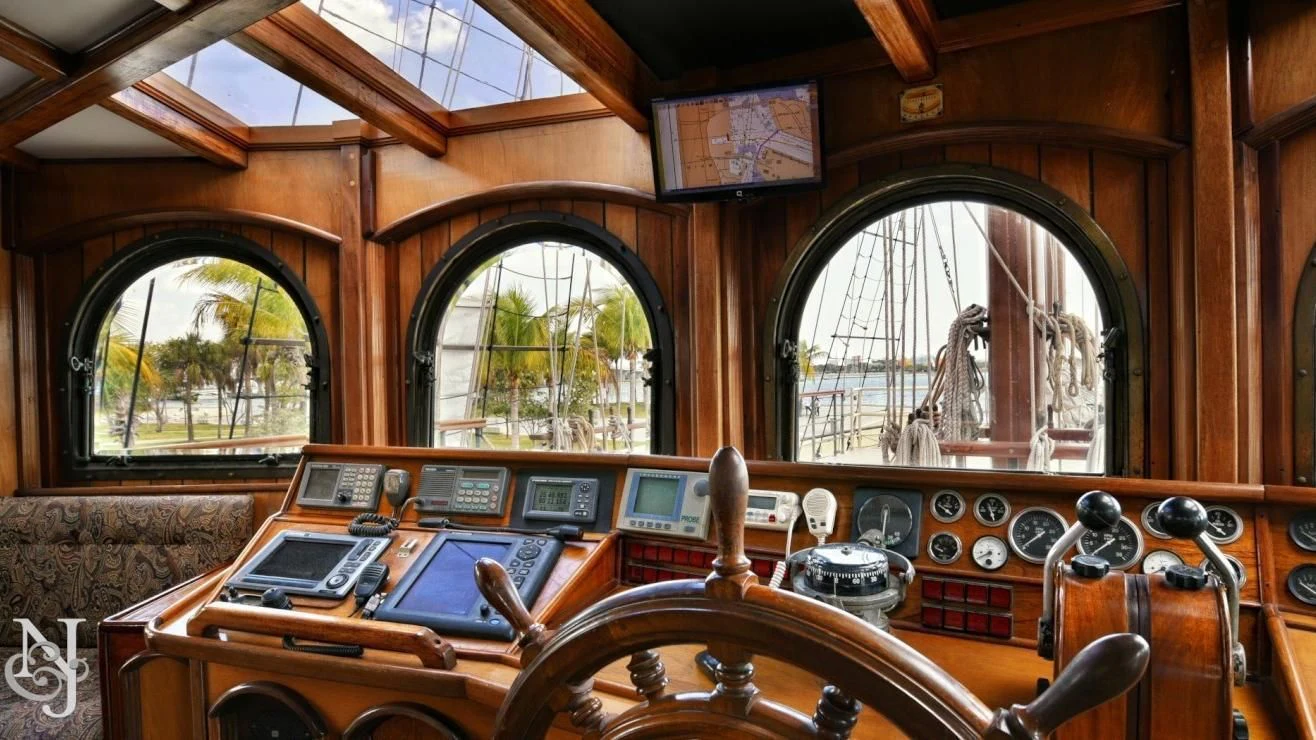 a room with a large mirror and a table with chairs aboard PEACEMAKER Yacht for Sale