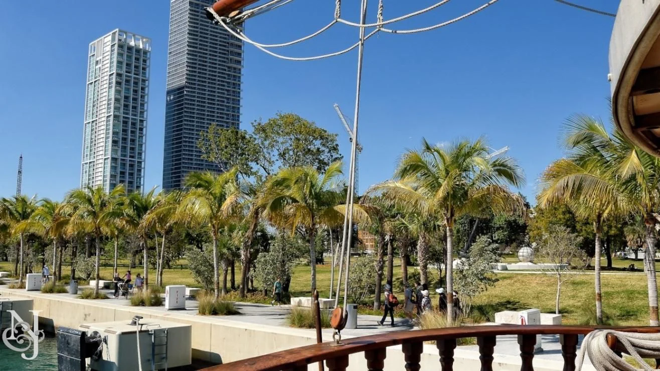 a group of people walking on a sidewalk next to a beach aboard PEACEMAKER Yacht for Sale