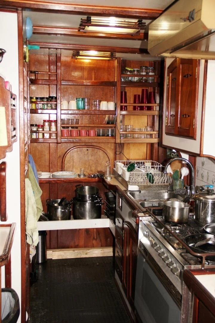 a kitchen with wooden cabinets aboard PEACEMAKER Yacht for Sale
