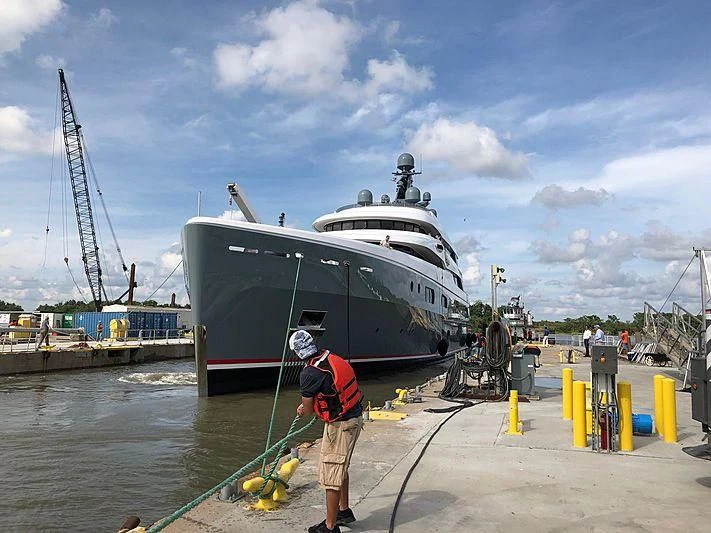a man standing next to a boat aboard AVIVA Yacht for Sale