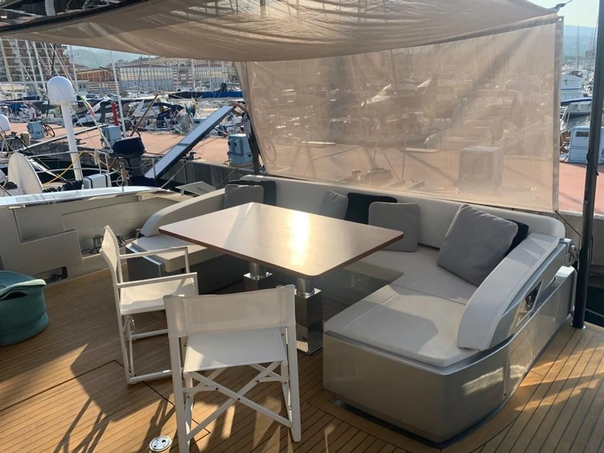 a room with a couch and a table with chairs aboard CHILUCE Yacht for Charter