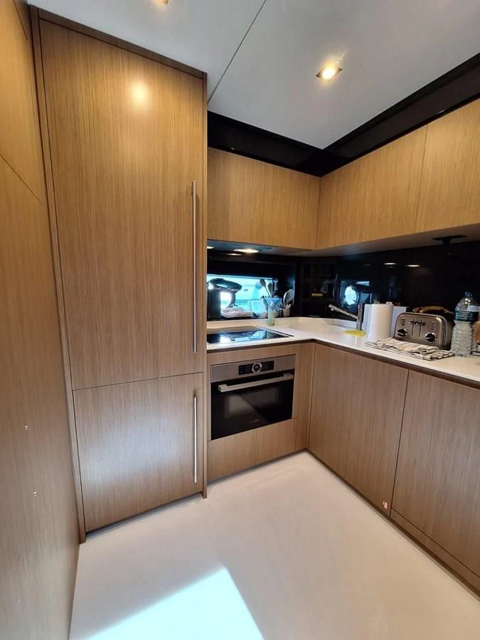a kitchen with wooden cabinets aboard CHILUCE Yacht for Charter