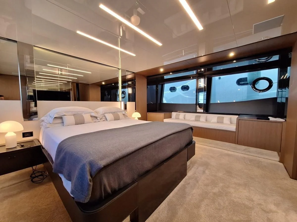 a room with a bed and a large window aboard CHILUCE Yacht for Charter