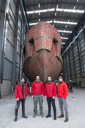 a group of people posing in front of a large sculpture aboard WATERLILY Yacht for Sale