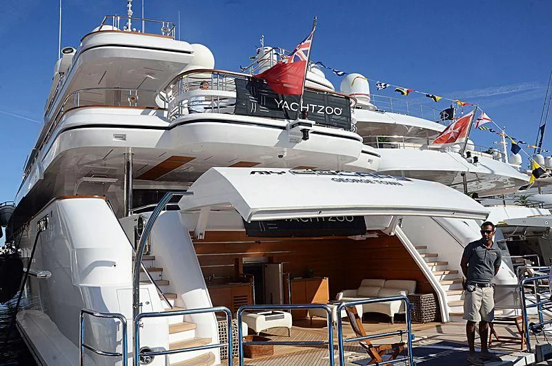 a man standing next to a large ship aboard MY ESCAPE Yacht for Sale