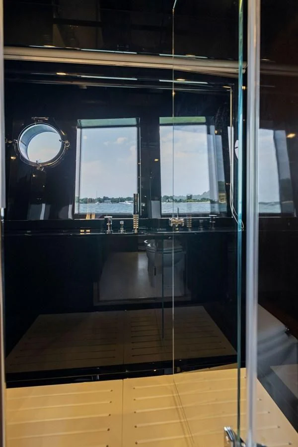 a large window with a round mirror aboard INDISCRETION Yacht for Sale