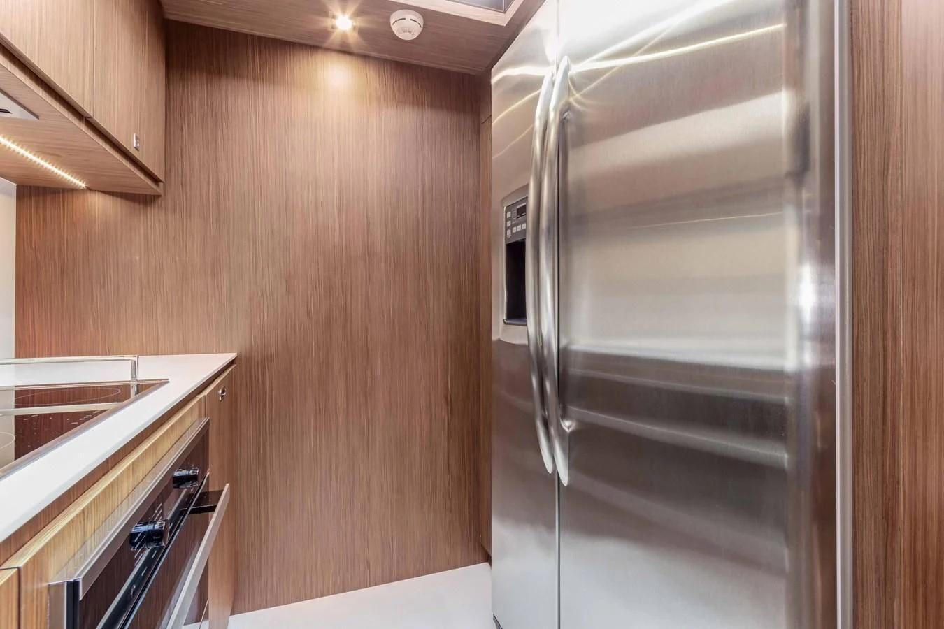 a kitchen with a stainless steel refrigerator aboard INDISCRETION Yacht for Sale