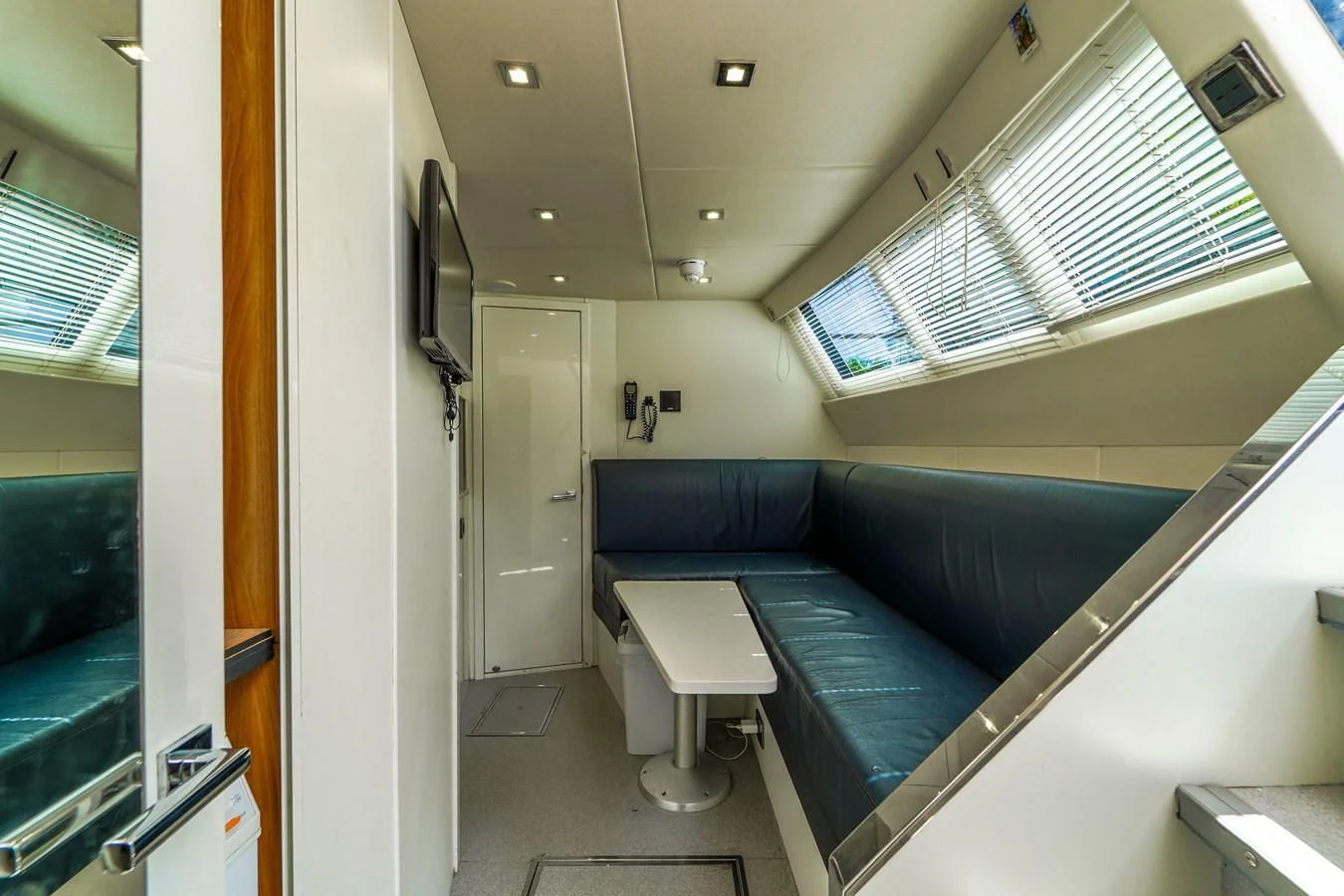 a room with a blue couch and a white table aboard 92' SUNSEEKER 2016 Yacht for Sale