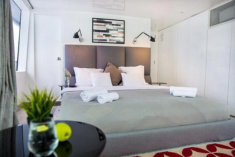 a bed with a blue bed spread aboard AZALEA Yacht for Sale