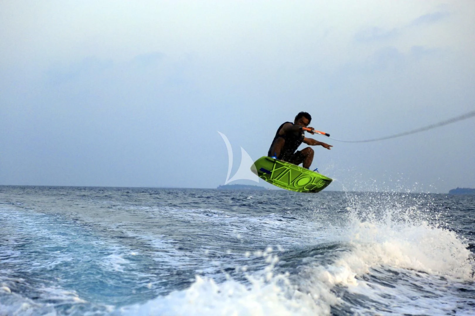 a man is surfing on the waves aboard AZALEA Yacht for Sale