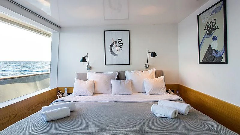 a bed with white sheets and pillows aboard AZALEA Yacht for Sale