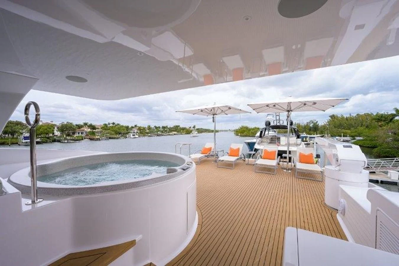 a large white lounge area with a pool and umbrellas aboard ODYSSEY Yacht for Sale