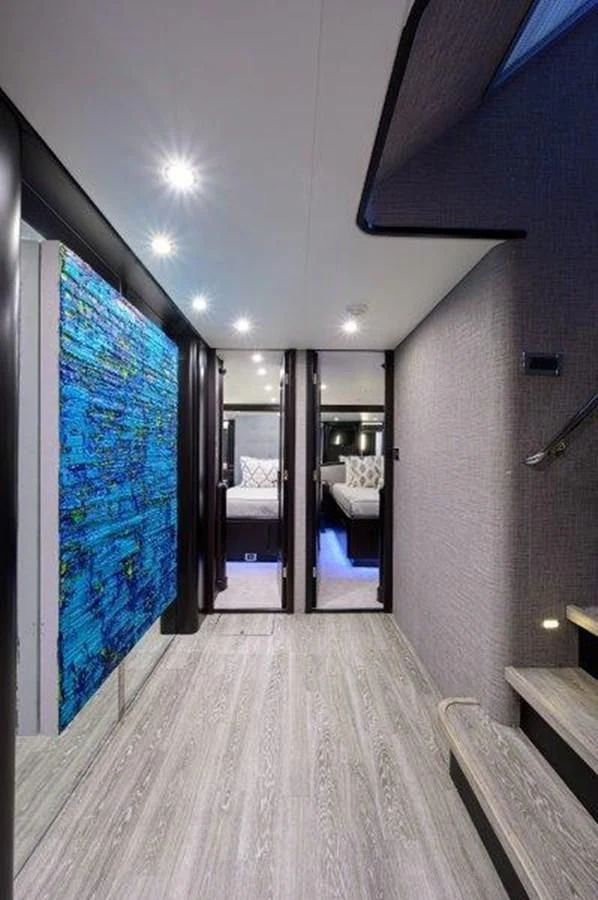 a room with a wood floor and a large mirror with a view of the city aboard ODYSSEY Yacht for Sale