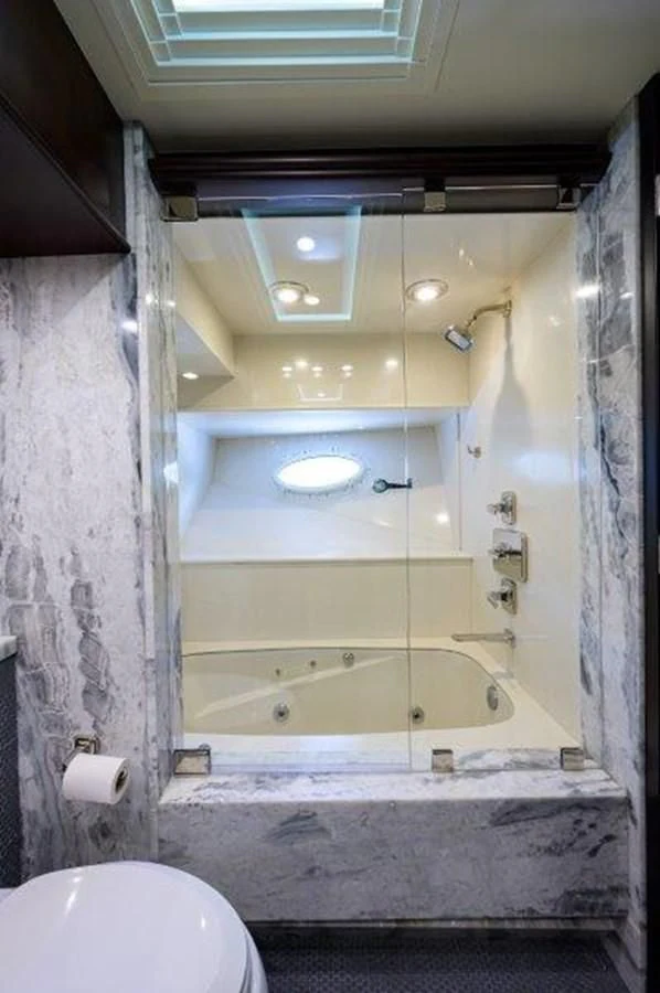 a bathroom with a tub and a sink aboard ODYSSEY Yacht for Sale