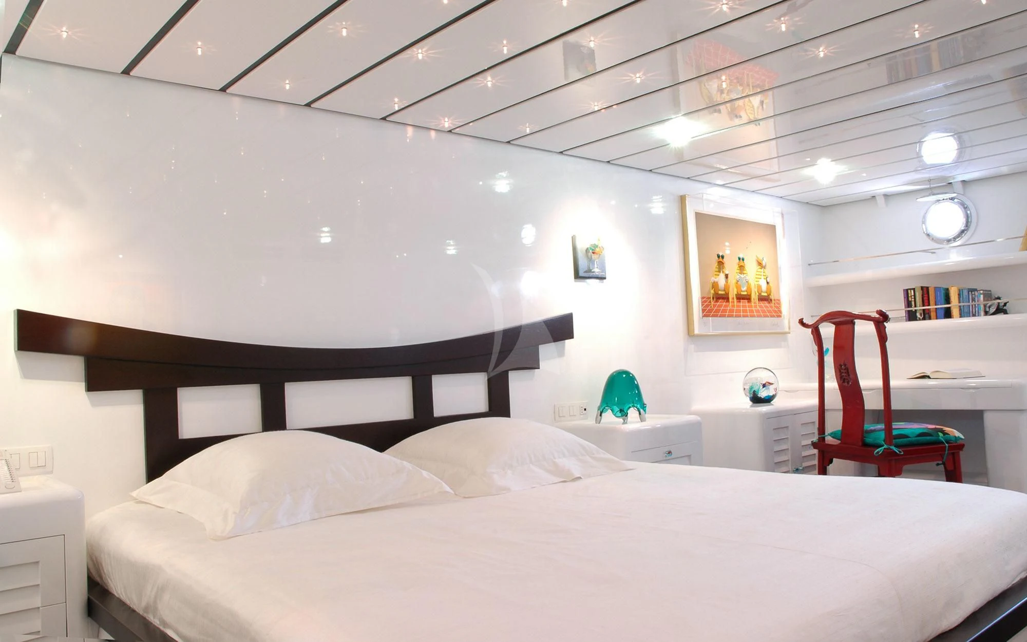 a bedroom with a red chair aboard MATA MUA Yacht for Sale
