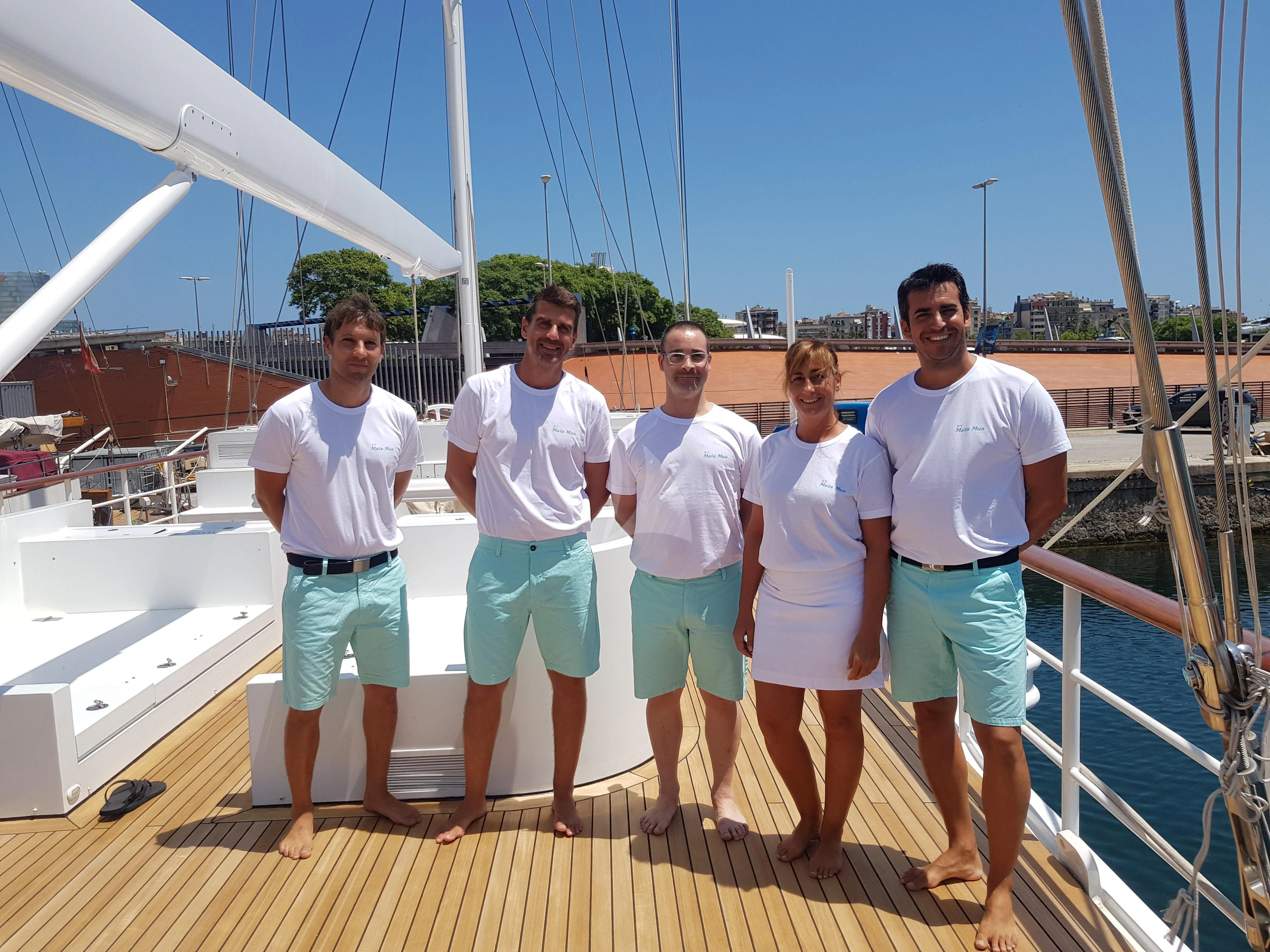 a group of people posing for a photo on a boat aboard MATA MUA Yacht for Sale