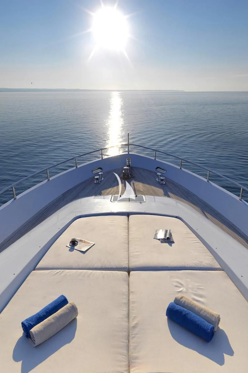 a deck with a railing and a body of water in the background aboard RUBY Yacht for Charter