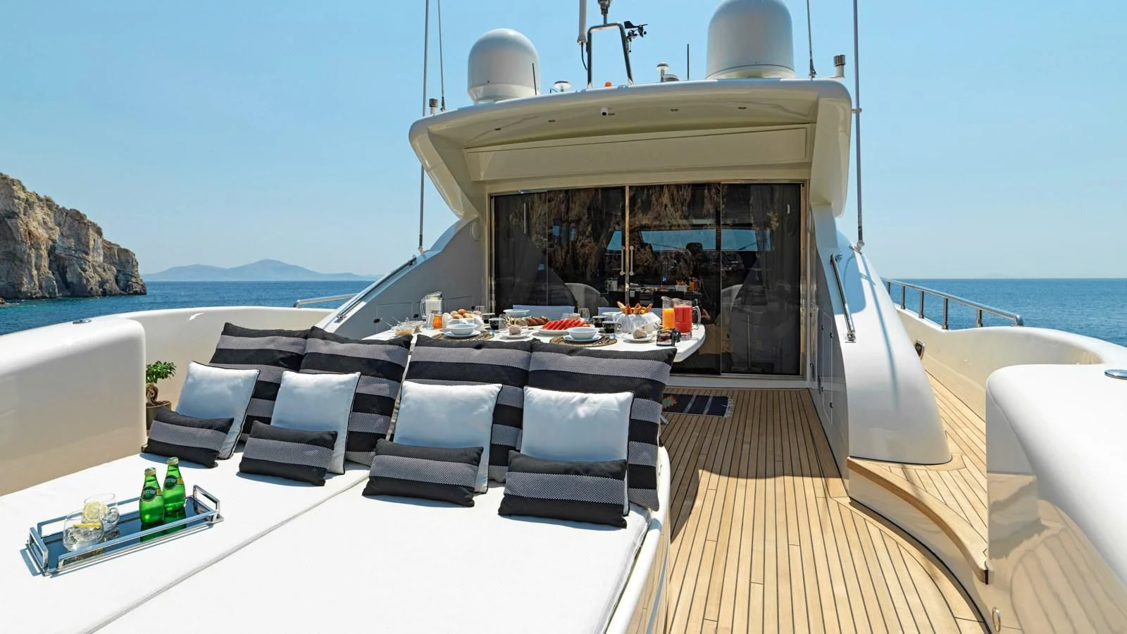 a deck with a table and chairs on it aboard RUBY Yacht for Charter