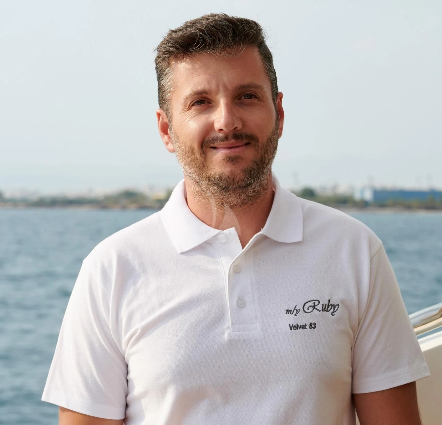 a man standing in front of a body of water aboard RUBY Yacht for Charter