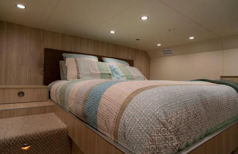 a bed with a blue and white comforter aboard LA BELLA CHERIE Yacht for Sale