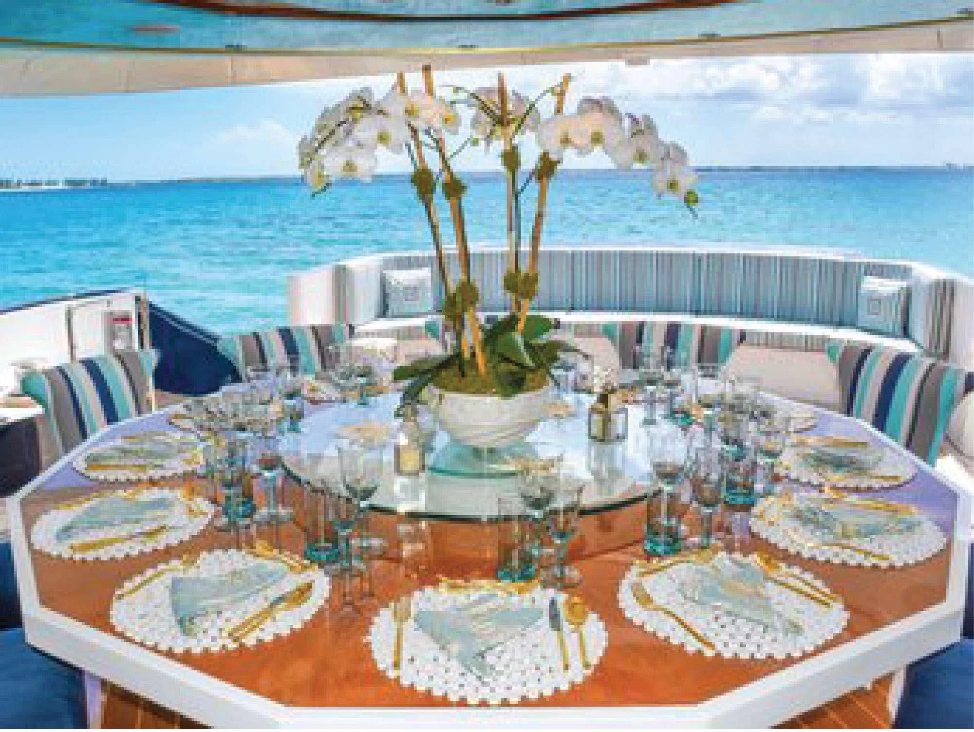 a table set with flowers aboard OCTOPUSSY Yacht for Sale