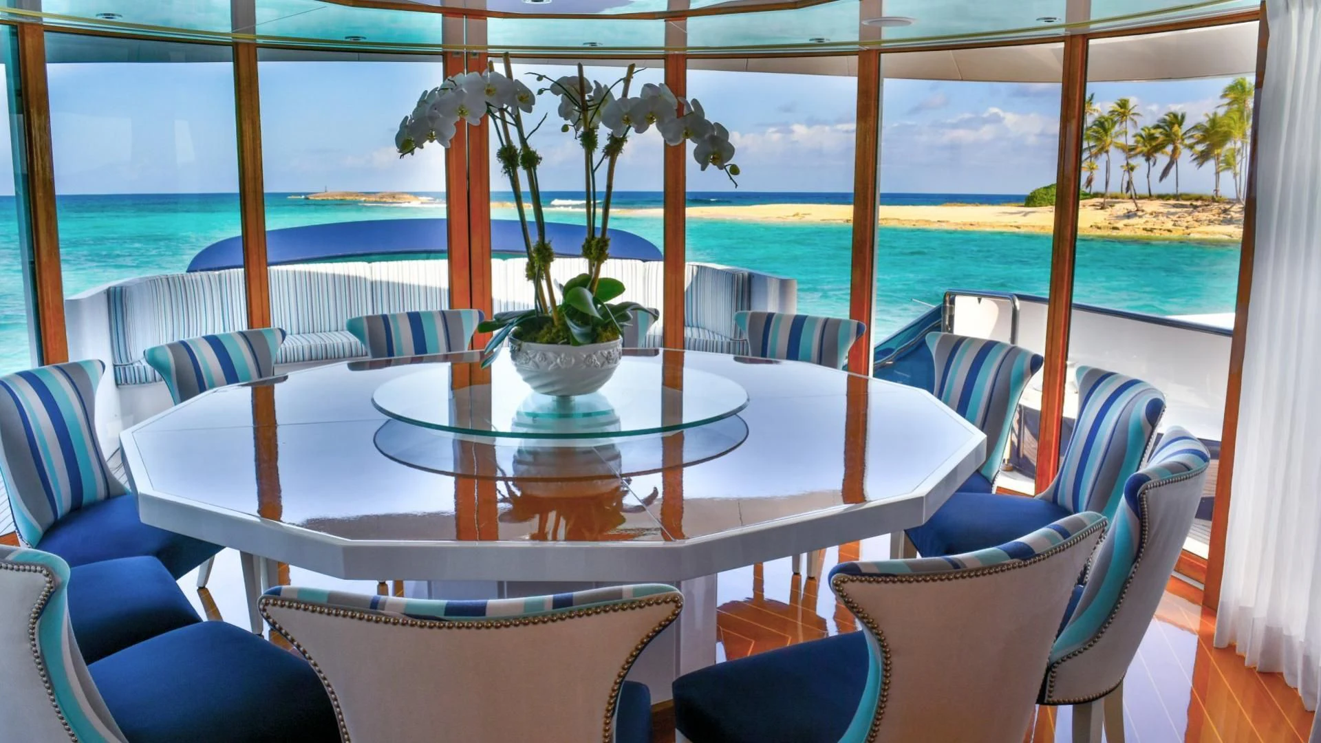 a table with chairs and plants on it aboard OCTOPUSSY Yacht for Sale