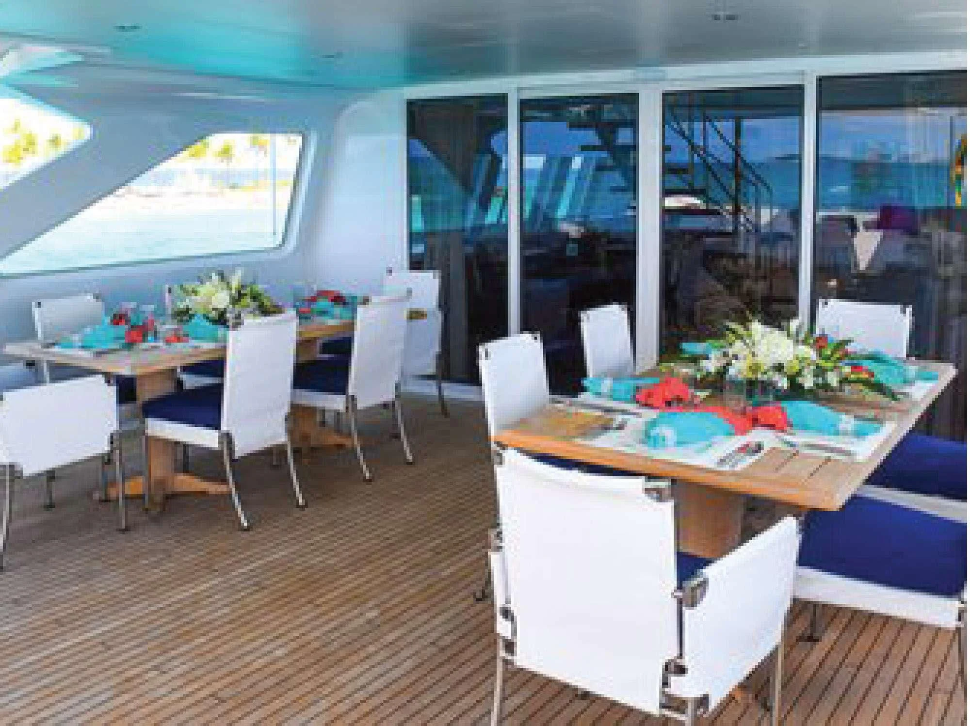 a room with tables and chairs aboard OCTOPUSSY Yacht for Sale