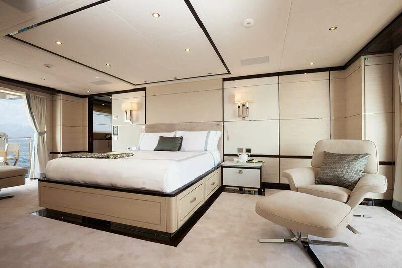 a modern bedroom with a bed and chair aboard BAMBOO Yacht for Sale