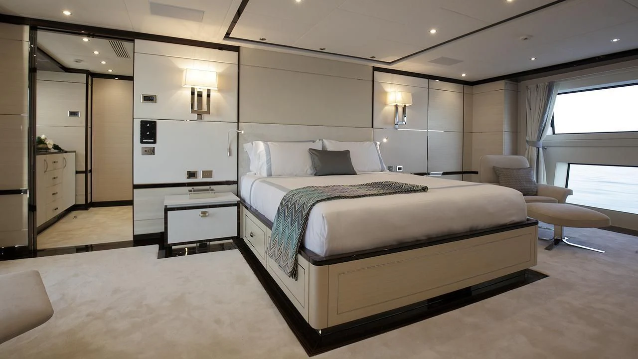 a large bedroom with a bed and a chair aboard BAMBOO Yacht for Sale