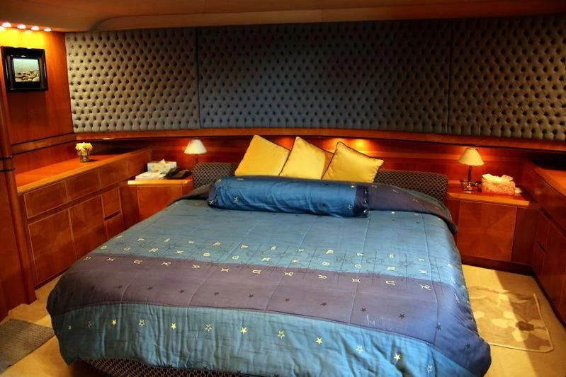 a bed with a blue comforter aboard GAMAYUN Yacht for Sale