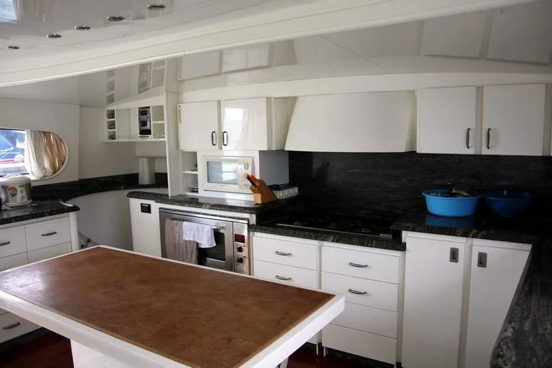 a kitchen with white cabinets aboard GAMAYUN Yacht for Sale