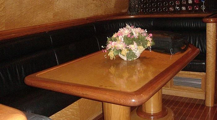 a wooden table with a vase of flowers on it aboard ABOU MAYA Yacht for Sale
