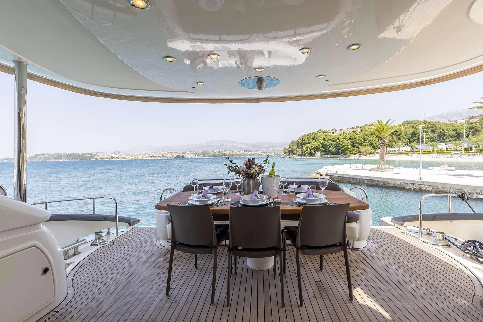 a table and chairs on a deck overlooking a body of water aboard SKYWATER Yacht for Sale