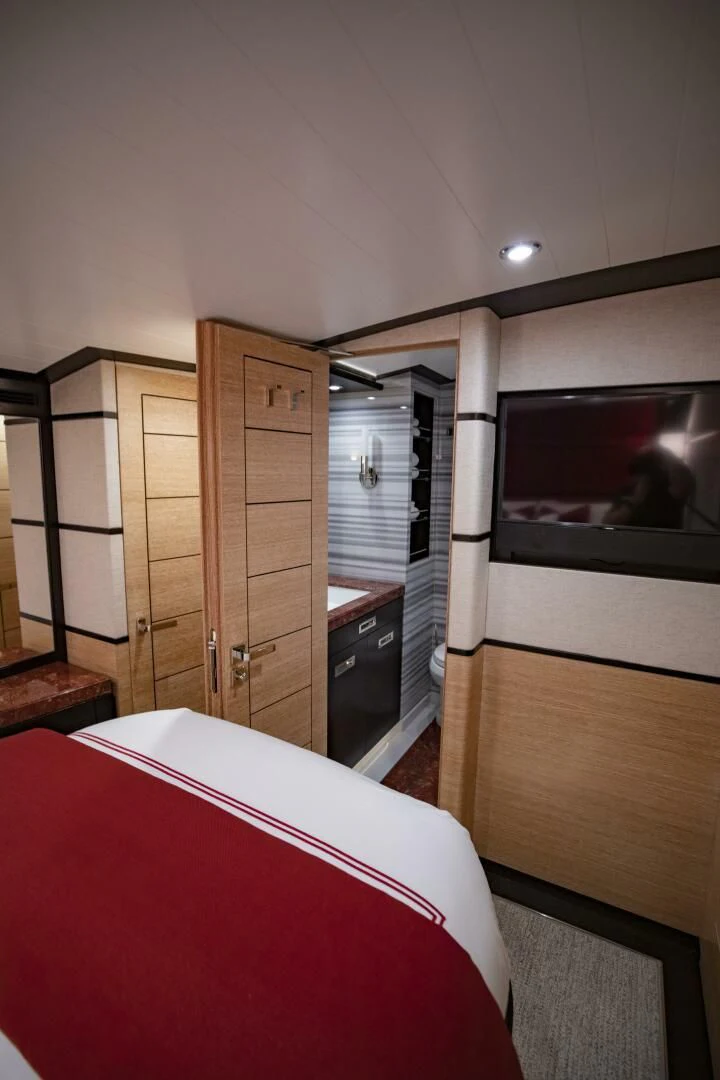 a bedroom with a bed and a tv aboard III AMIGOS Yacht for Sale
