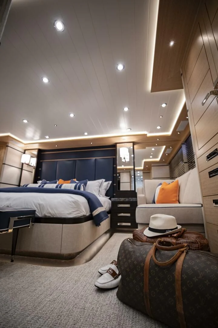 a bedroom with a bed and a chair aboard III AMIGOS Yacht for Sale