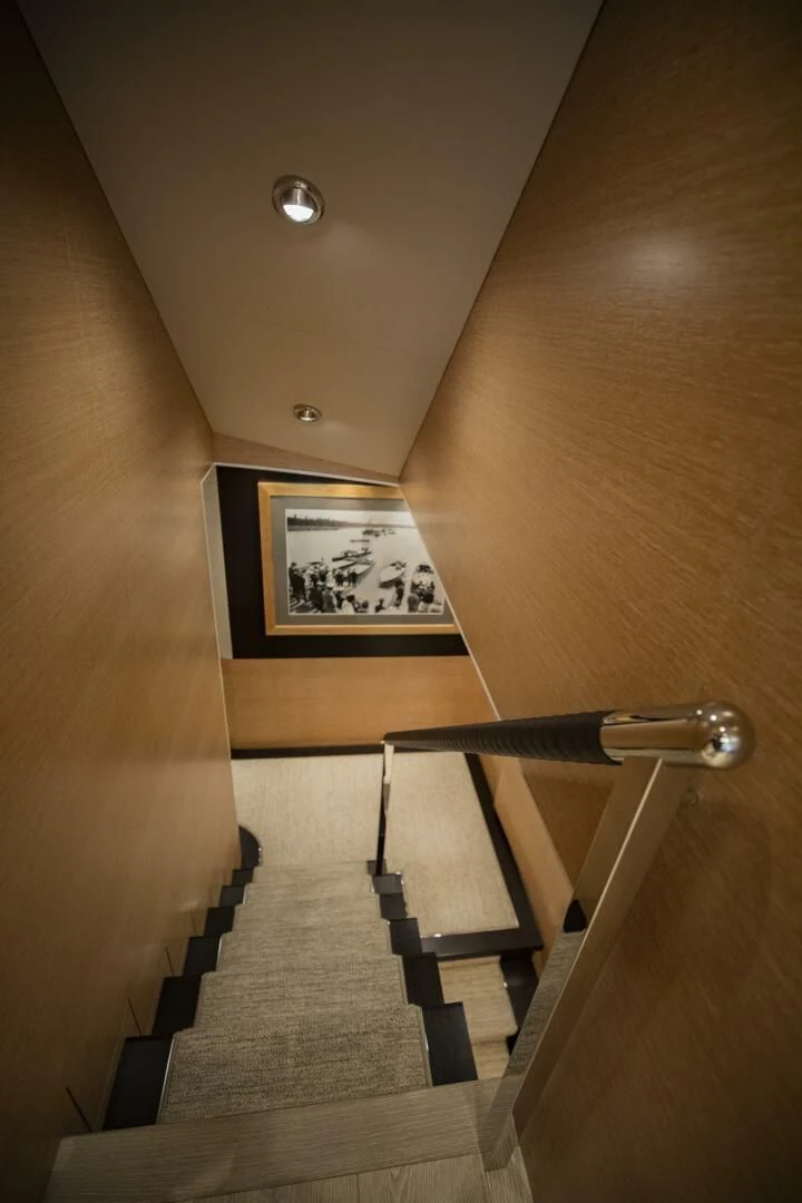 a wooden staircase with a picture on the wall aboard III AMIGOS Yacht for Sale
