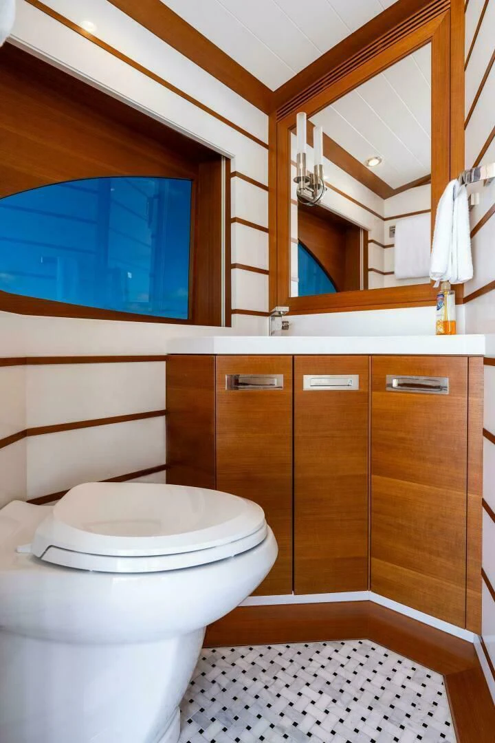 a bathroom with a toilet and a mirror aboard III AMIGOS Yacht for Sale