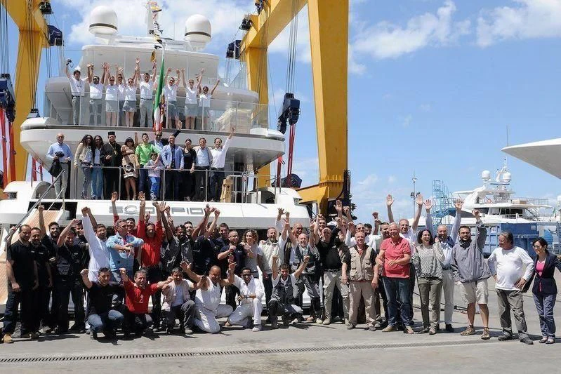 a group of people posing for a photo next to a large boat aboard SCORPION Yacht for Charter
