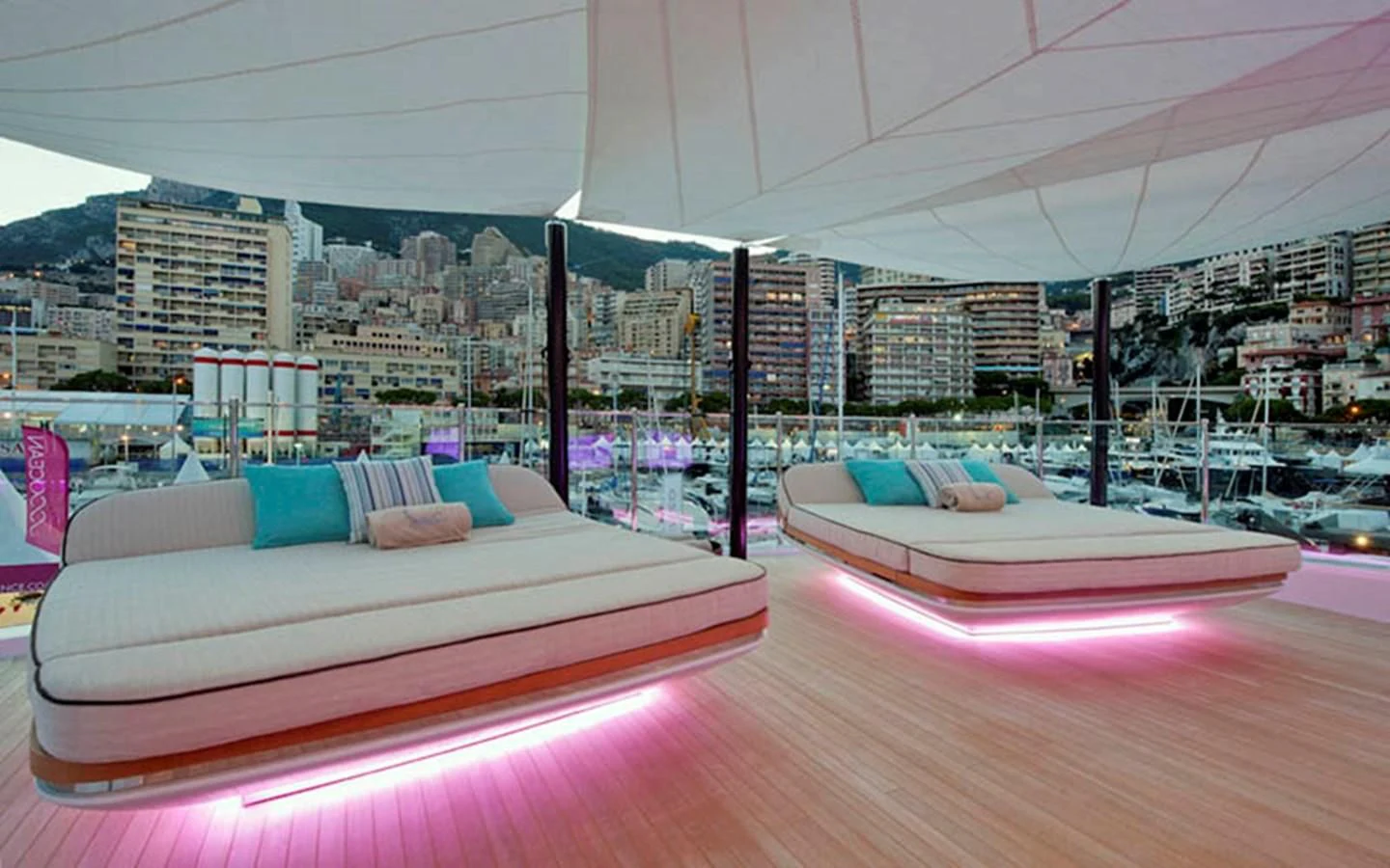 a room with a large bed and a city in the background aboard SCORPION Yacht for Charter