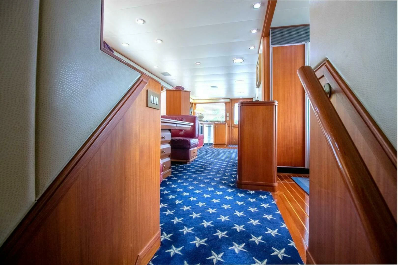 a hallway with a blue carpet aboard CHAIRMAN Yacht for Sale
