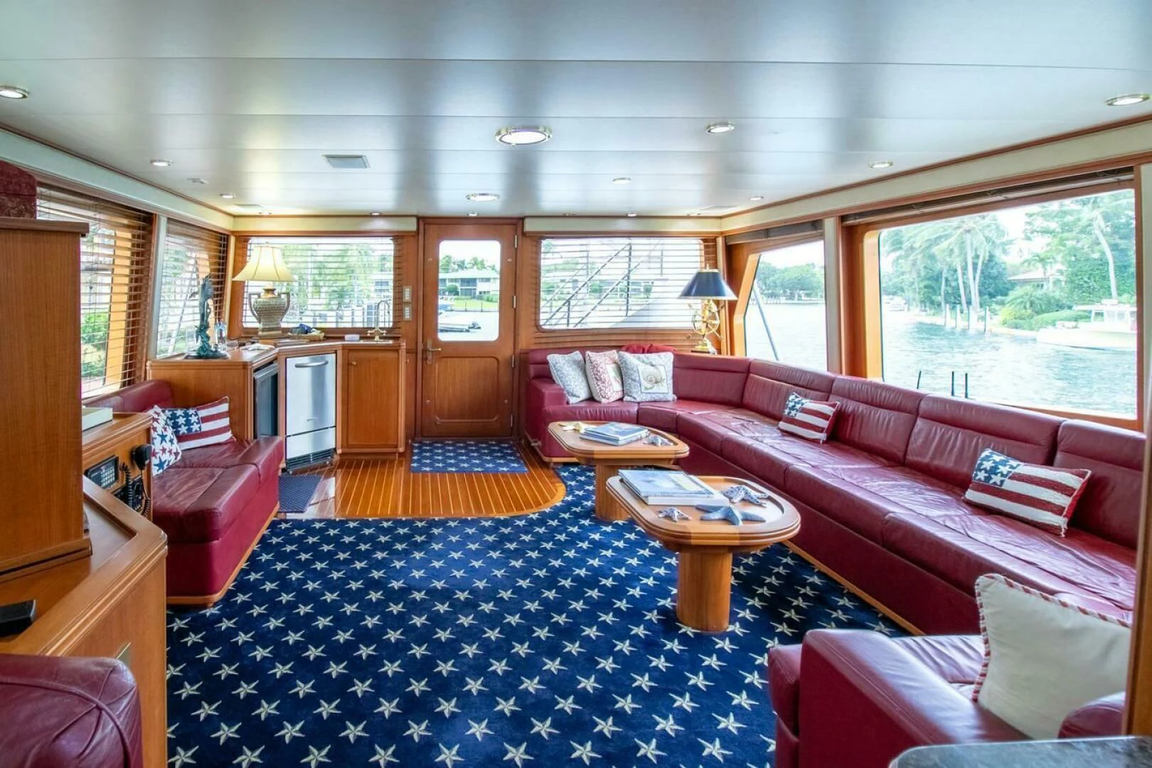 a living room with a red couch and a blue rug aboard CHAIRMAN Yacht for Sale
