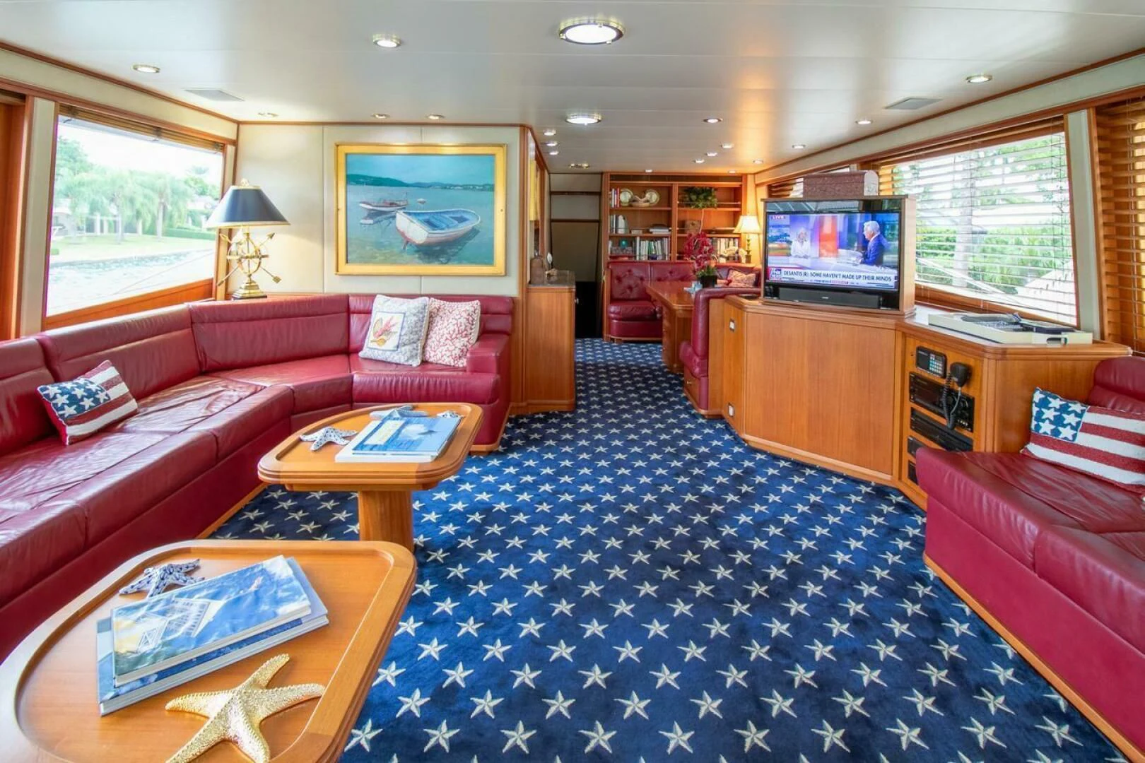 a living room with a red couch and a television aboard CHAIRMAN Yacht for Sale