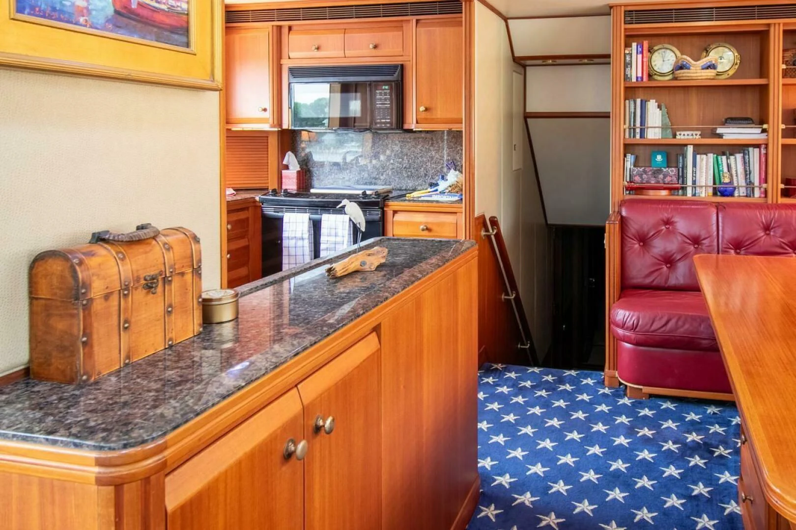 a kitchen with a red couch and a wooden cabinet aboard CHAIRMAN Yacht for Sale