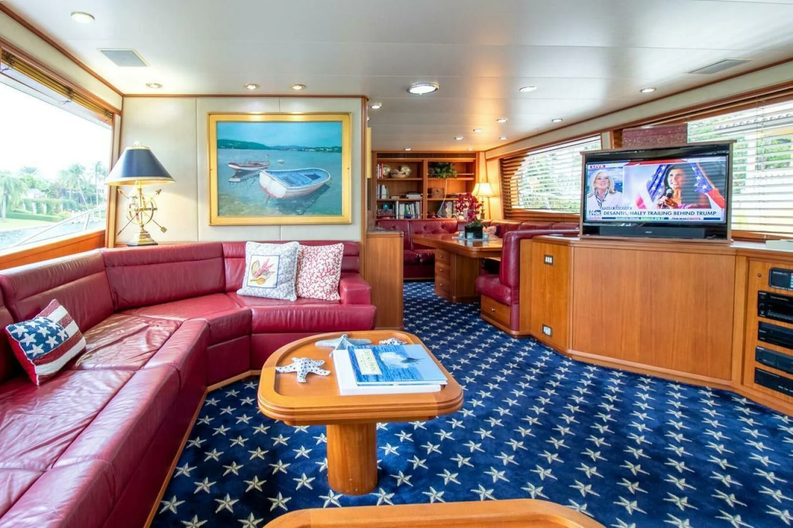 a living room with a red couch and a table aboard CHAIRMAN Yacht for Sale