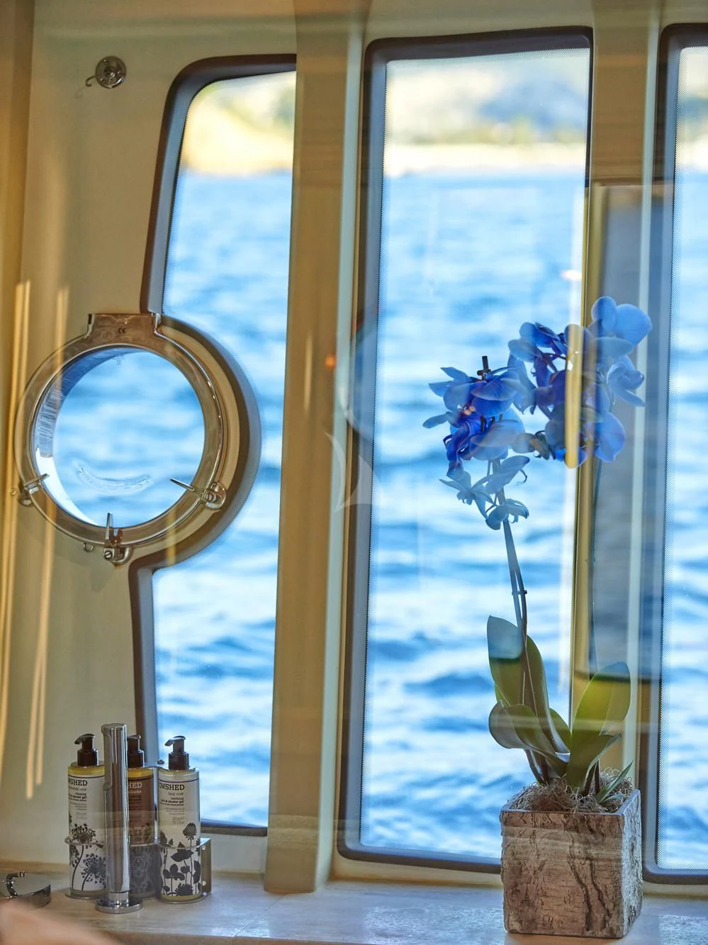 a vase of flowers sits in a window sill aboard JULIE M Yacht for Sale