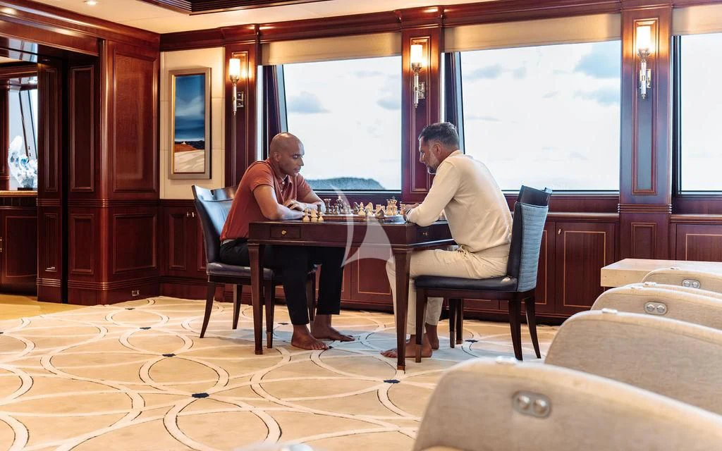 a man and a woman sitting at a table playing chess aboard LADY BETH Yacht for Sale